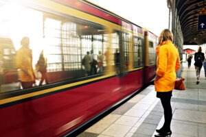 Woman in a yellow coat waiting for public transportation