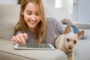 Woman sitting on a couch with a small dog
